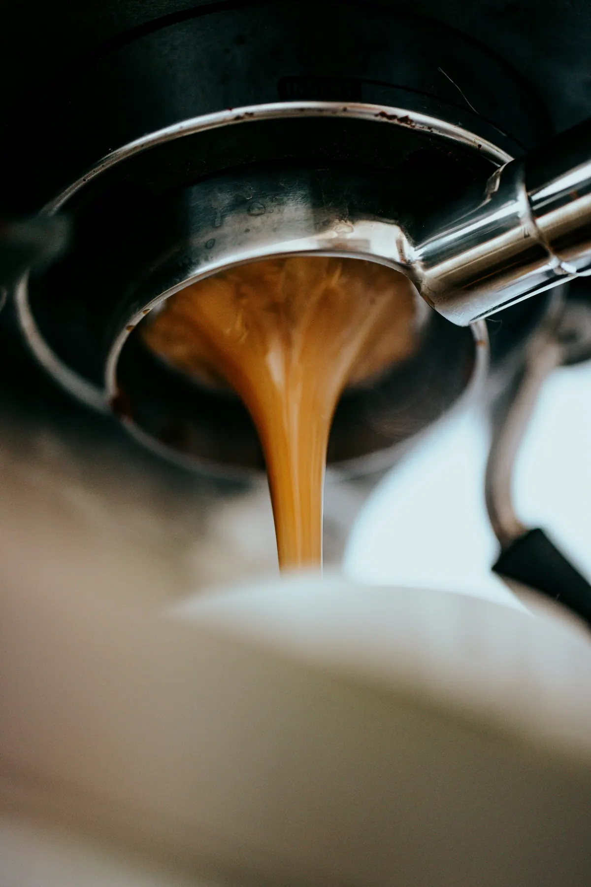 Espresso running from a portafilter in a thick amber stream